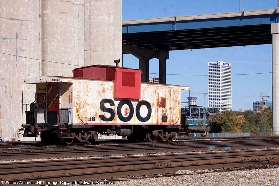Neutered caboose 138, formerly tethered to Soo crane 751203, was downgraded to shoving platform
